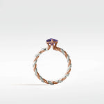 Side profile of the Violet Elm Engagement Ring with a twisted rose and white gold diamond band and a purple center stone.