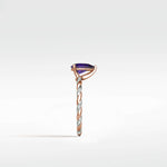 Side view of the Violet Elm Engagement Ring with a pear-shaped amethyst on a twisted two-tone rose gold and diamond pavé band.