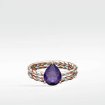 Violet Elm Engagement Ring with a pear-shaped purple gem on a twisted rose and white gold diamond band.