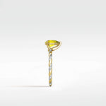 Side profile of the Canary Elm Engagement Ring with a pear-shaped yellow stone on a twisted two-tone gold and diamond band.