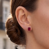 A close-up of a model's ear, wearing an emerald-cut ruby stud earring from the Lark & Berry London Bridge collection.