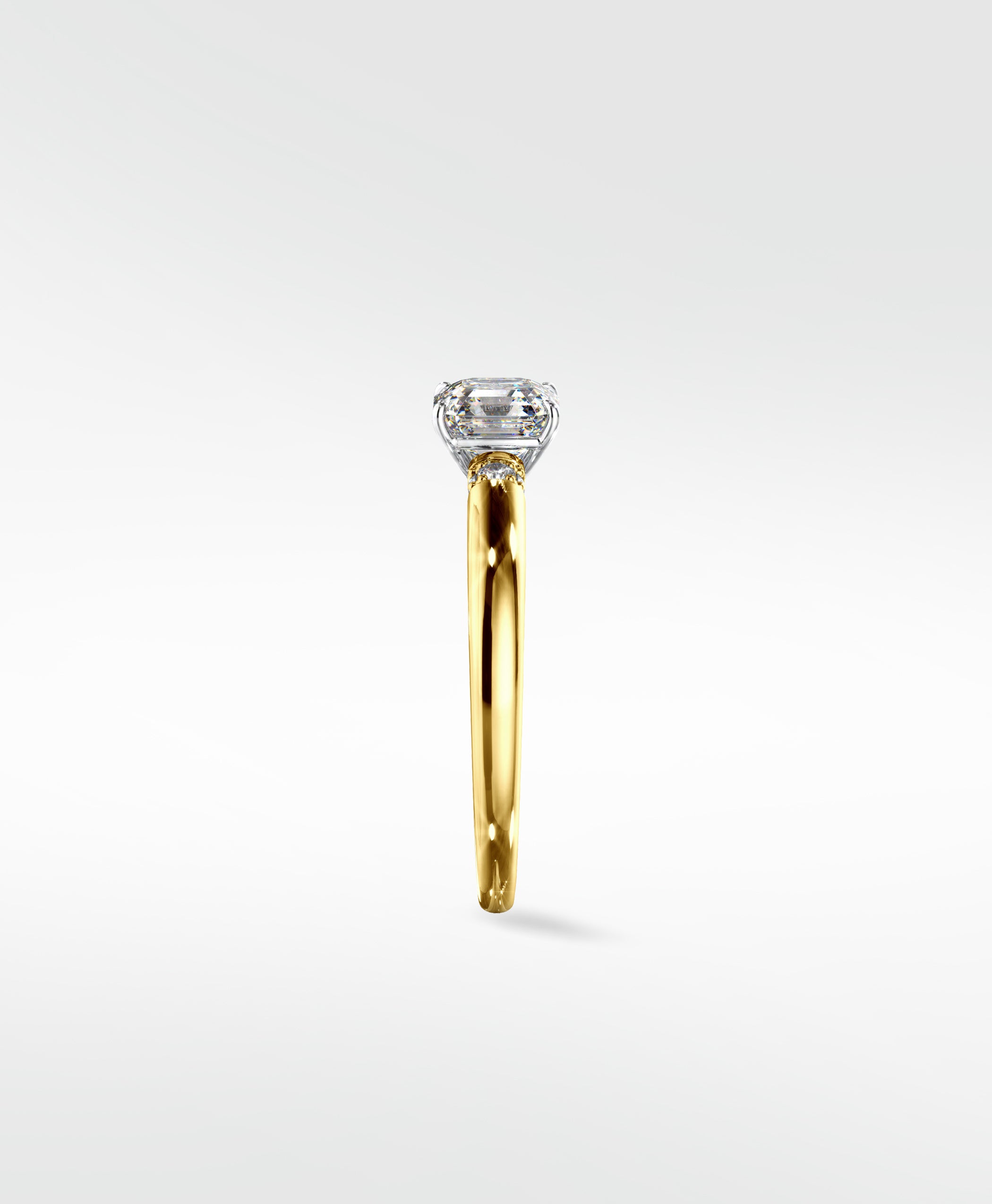 Side profile of the Cacao Engagement Ring in yellow gold with an emerald-cut diamond in a vintage-style platinum setting.