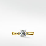 Cacao Engagement Ring in yellow gold, featuring a large Asscher-cut diamond flanked by two smaller round diamonds.