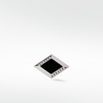 A single Clarke cufflink in matte silver, shaped like a diamond with a black center and pavé diamond accents.