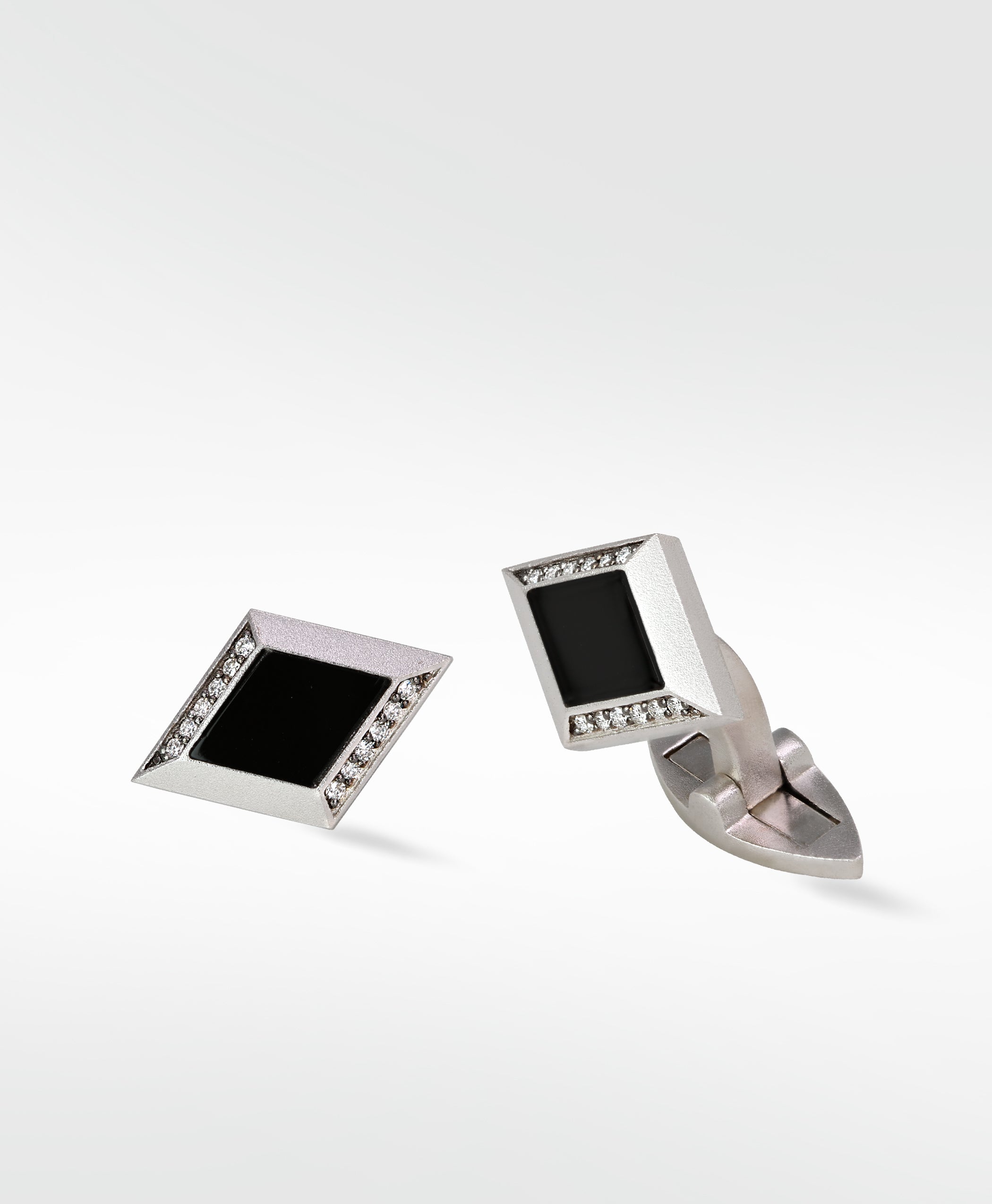 Pair of Clarke Cufflinks in matte silver, featuring a diamond shape with black inlay and pavé diamond details.