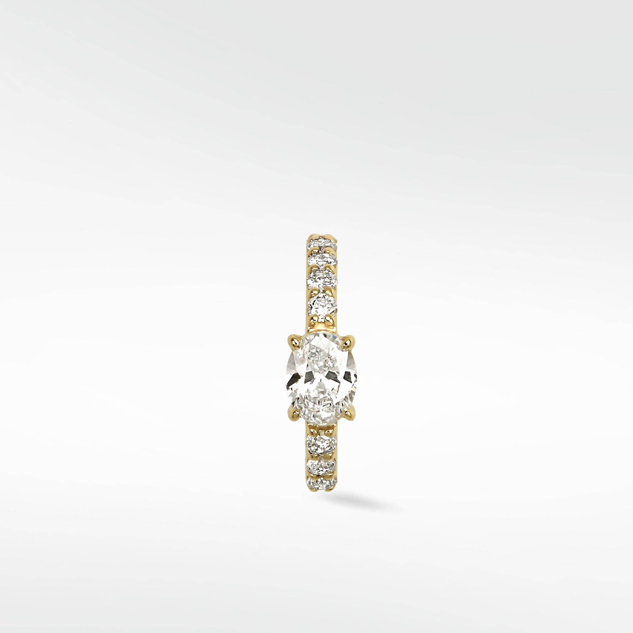 Front view of the Modernist Oval Diamond Hoop with a central oval diamond and a pavé diamond band set in yellow gold.