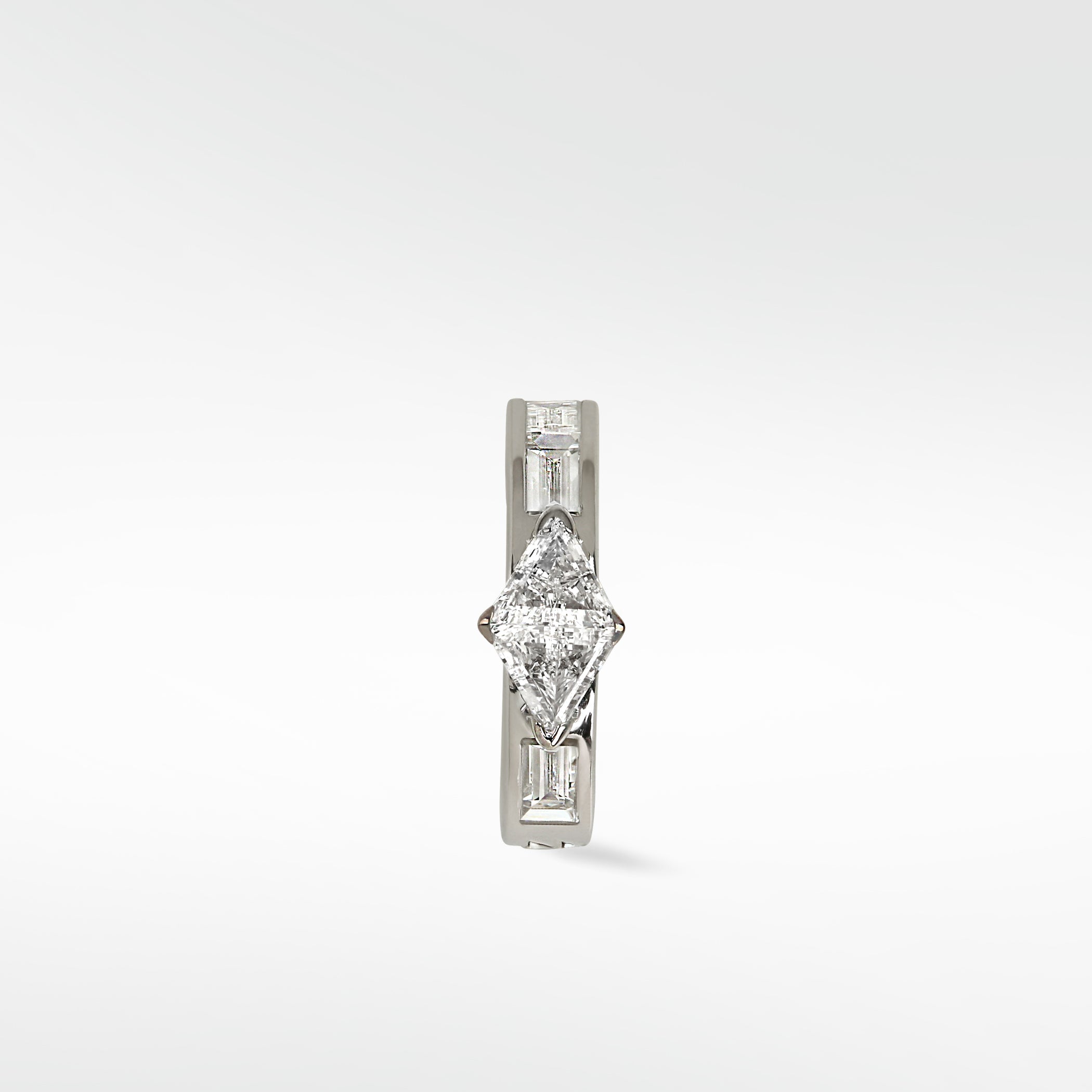 A white gold Modernist hoop earring with a central triangle diamond and baguette diamond accents, on a white background.