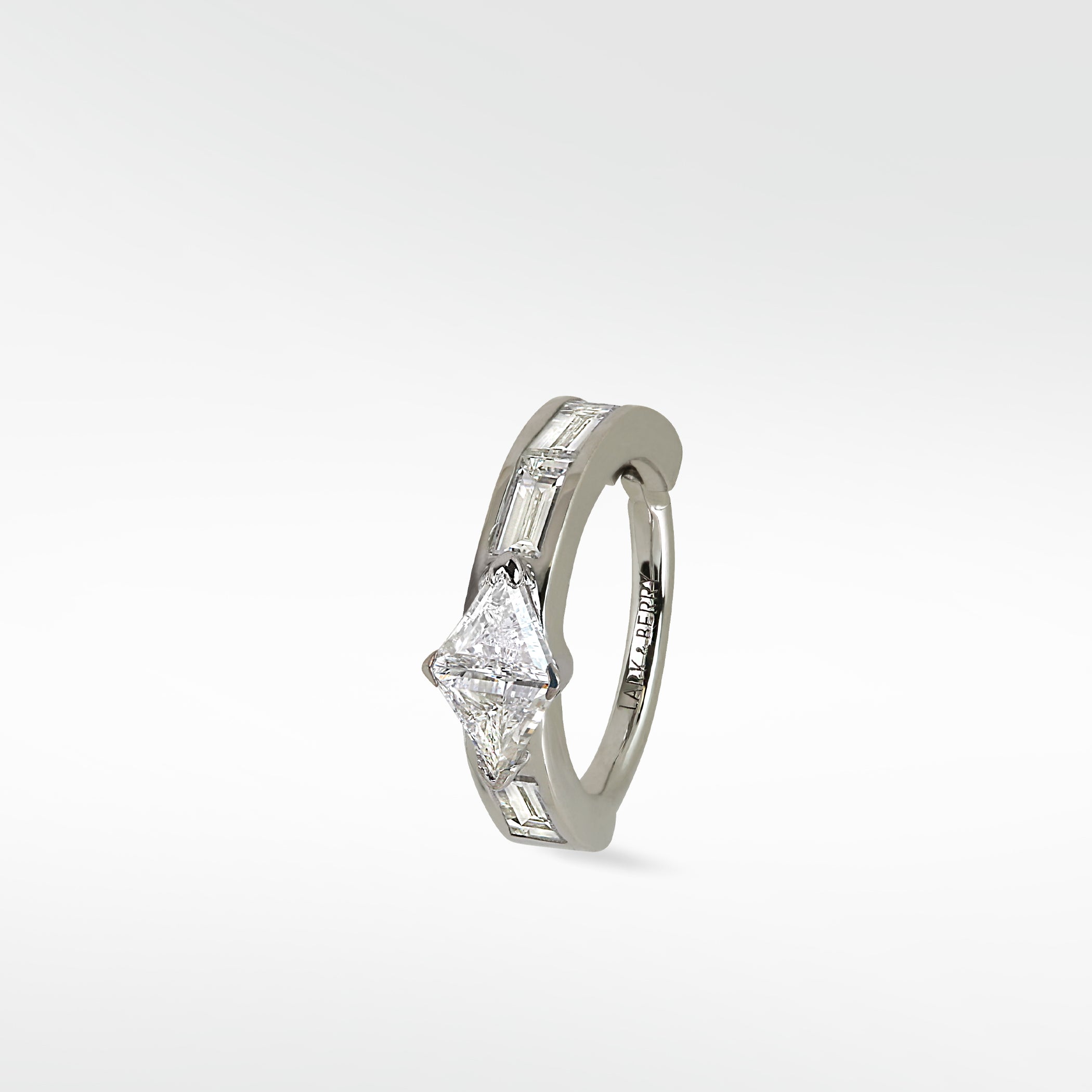 Modernist hoop earring in white gold with a triangle diamond and channel-set baguette diamonds.