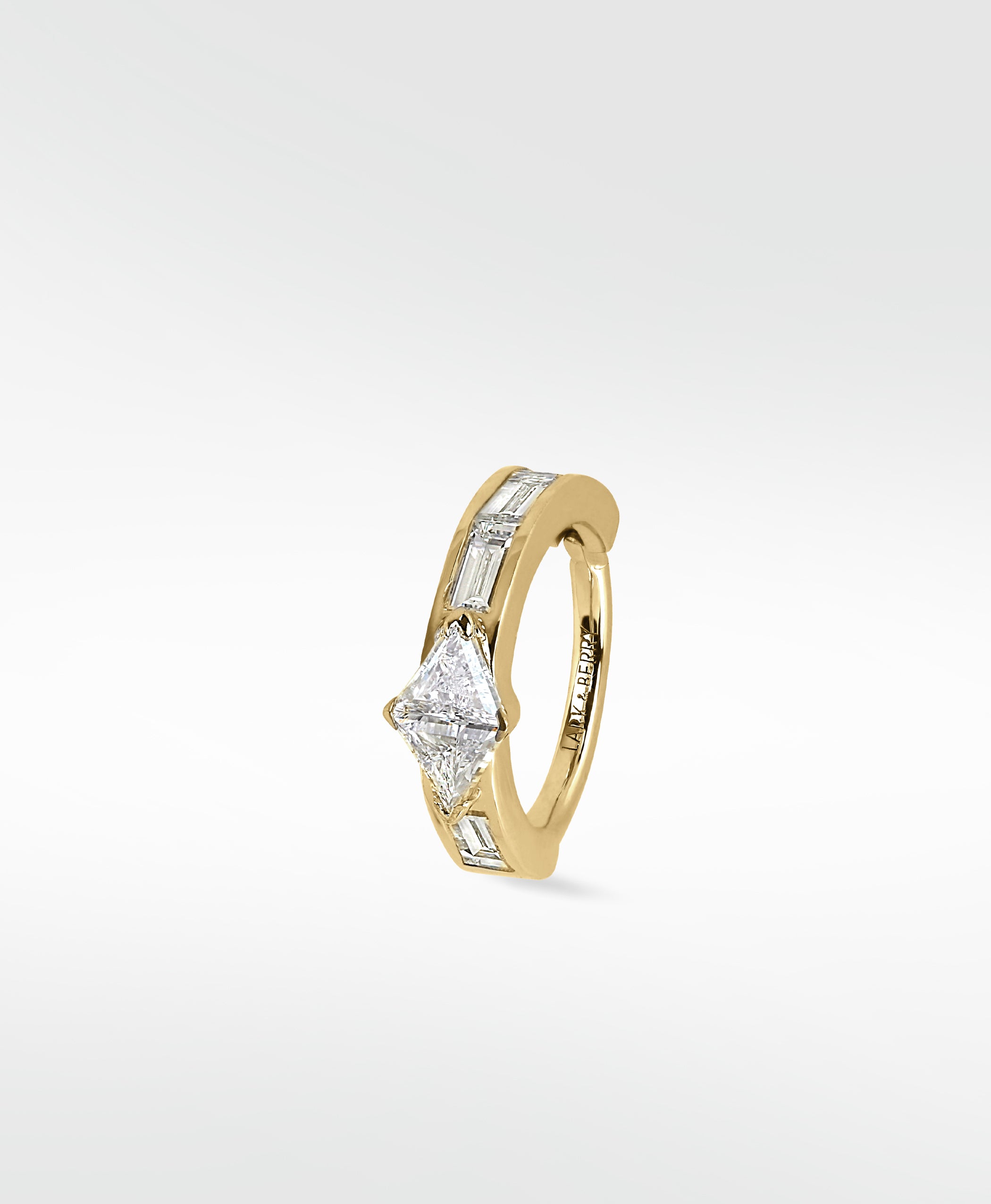 A yellow gold Modernist hoop earring featuring a central triangle diamond and channel-set baguette diamonds on a white background.