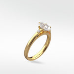 The Kentia Engagement Ring in yellow gold, featuring a marquise-cut diamond with two round accent stones.