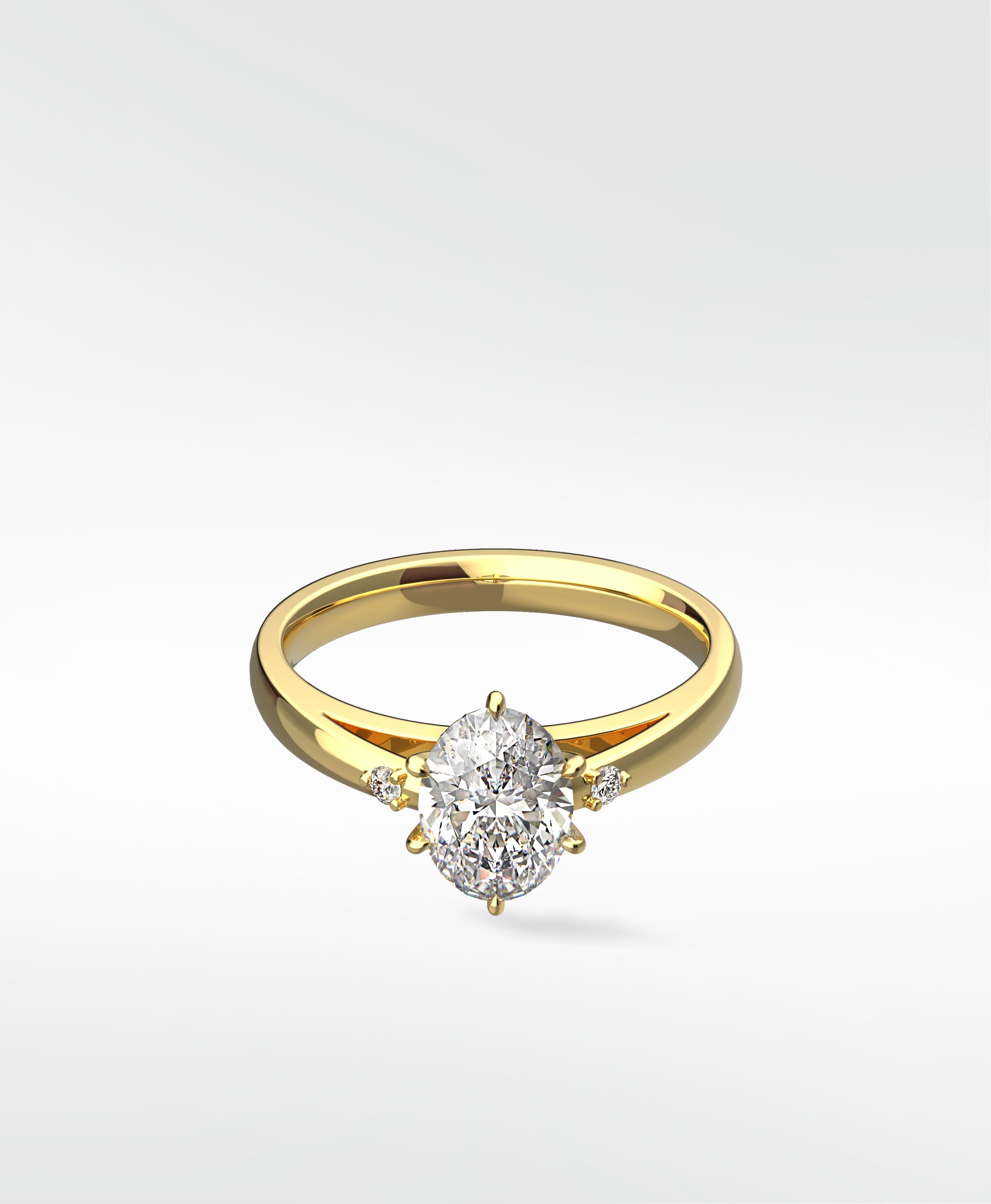 Kentia Engagement Ring by Lark & Berry in yellow gold, featuring a central oval diamond with two round accent diamonds.