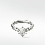 The Kentia Engagement Ring in white gold, featuring a brilliant oval diamond flanked by two smaller accent diamonds.