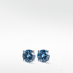 Pair of brilliant round-cut lime blue diamond stud earrings in a silver-toned four-prong setting.