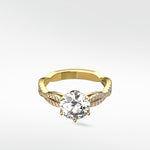 A yellow gold engagement ring with a round brilliant diamond set on a pavé-encrusted split shank band.
