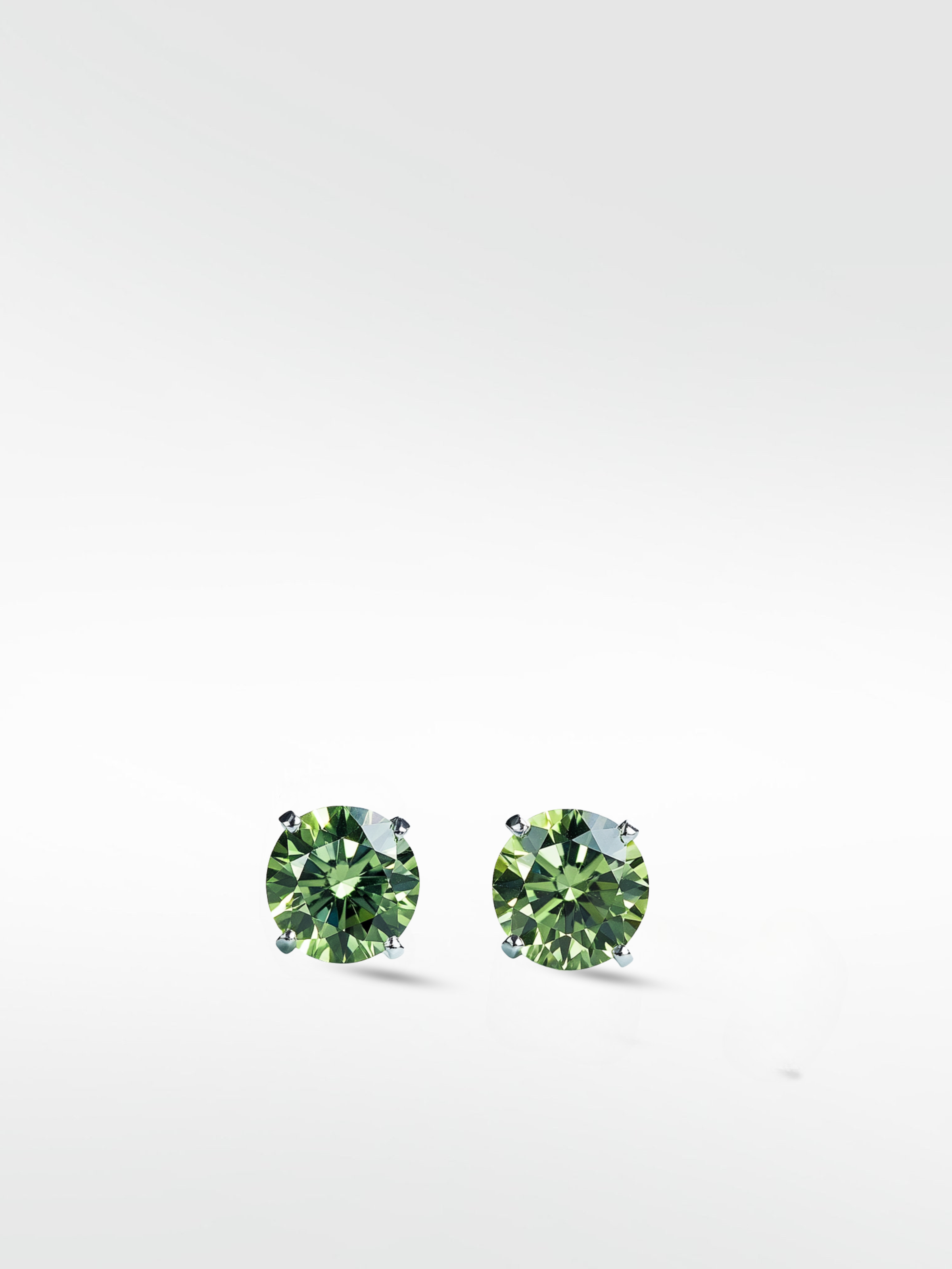 A pair of brilliant round-cut Lime Green Diamond stud earrings in a simple four-prong setting on a white background.