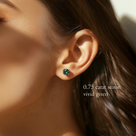 Close-up of a model's ear showing a brilliant round-cut, vivid green 0.75 carat diamond stud earring.