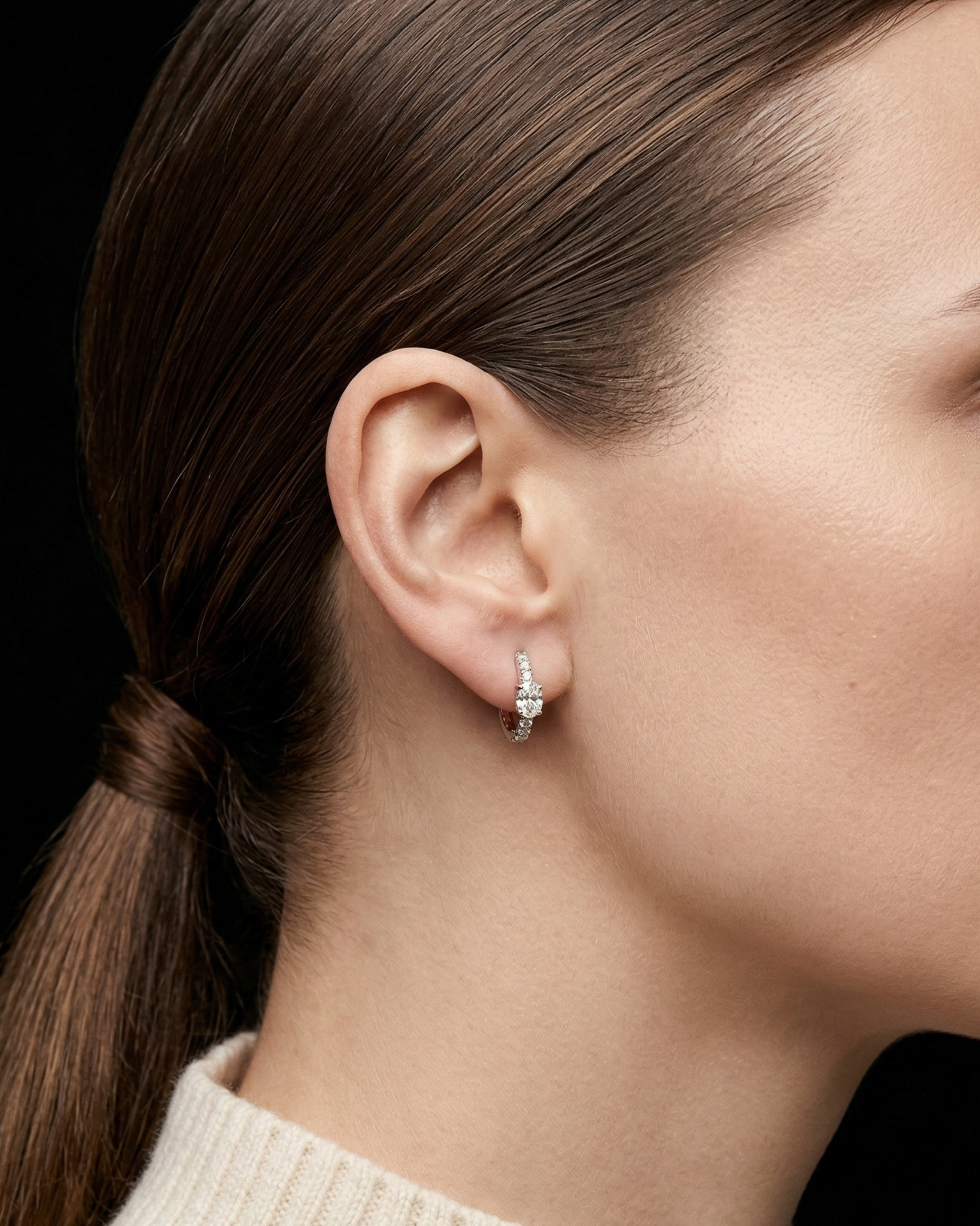Profile view of a model wearing the elegant Lark & Berry Modernist Oval Diamond Hoop, featuring a central oval diamond.