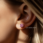 Close-up of a model's ear wearing a 2.5 carat brilliant round cut pink diamond stud earring.