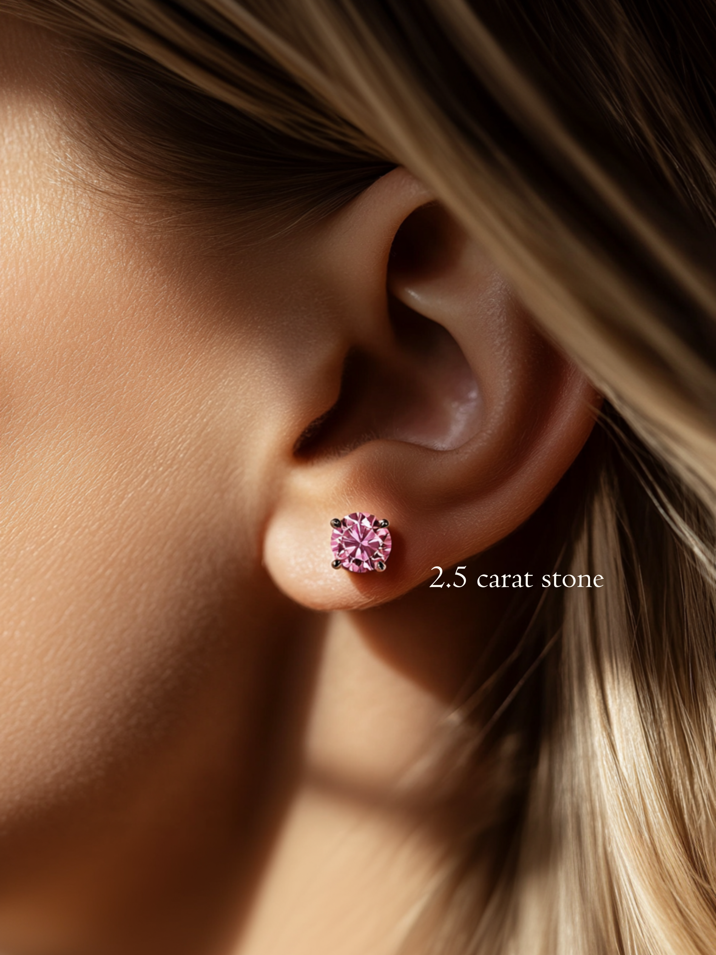 Close-up of a model's ear wearing a 2.5 carat brilliant round cut pink diamond stud earring.