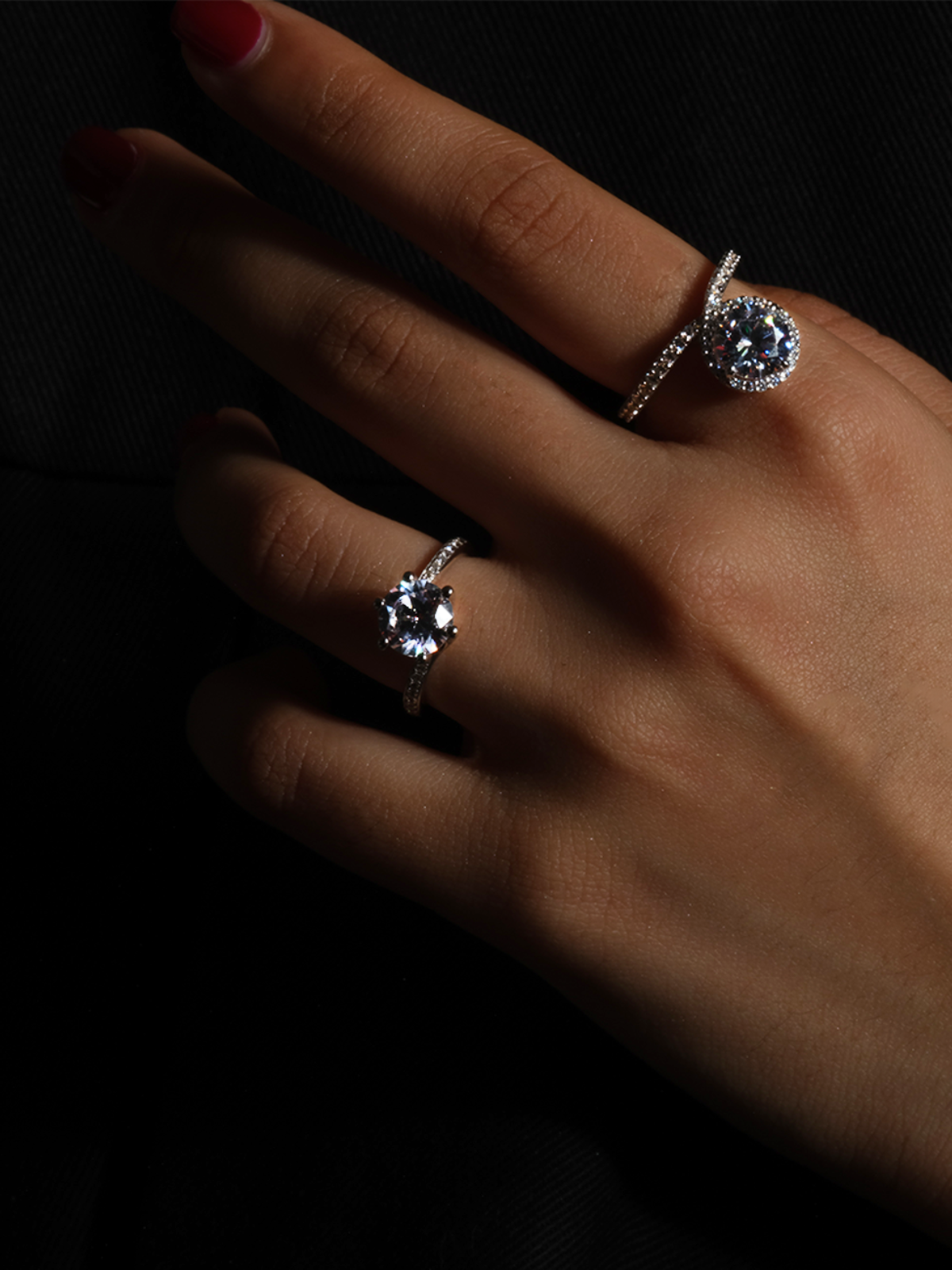The Lark & Berry Wild Cherry Diamond Engagement Ring with a halo setting, modeled on a hand against a dark background.