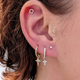 Close-up of a curated ear featuring a gold Celestial Diamond star charm on a hoop, styled with other diamond earrings and studs.