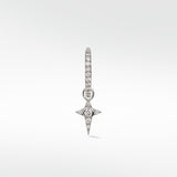 A Celestial Diamond Charm in white gold with a pavé star design hanging from a small diamond hoop earring.