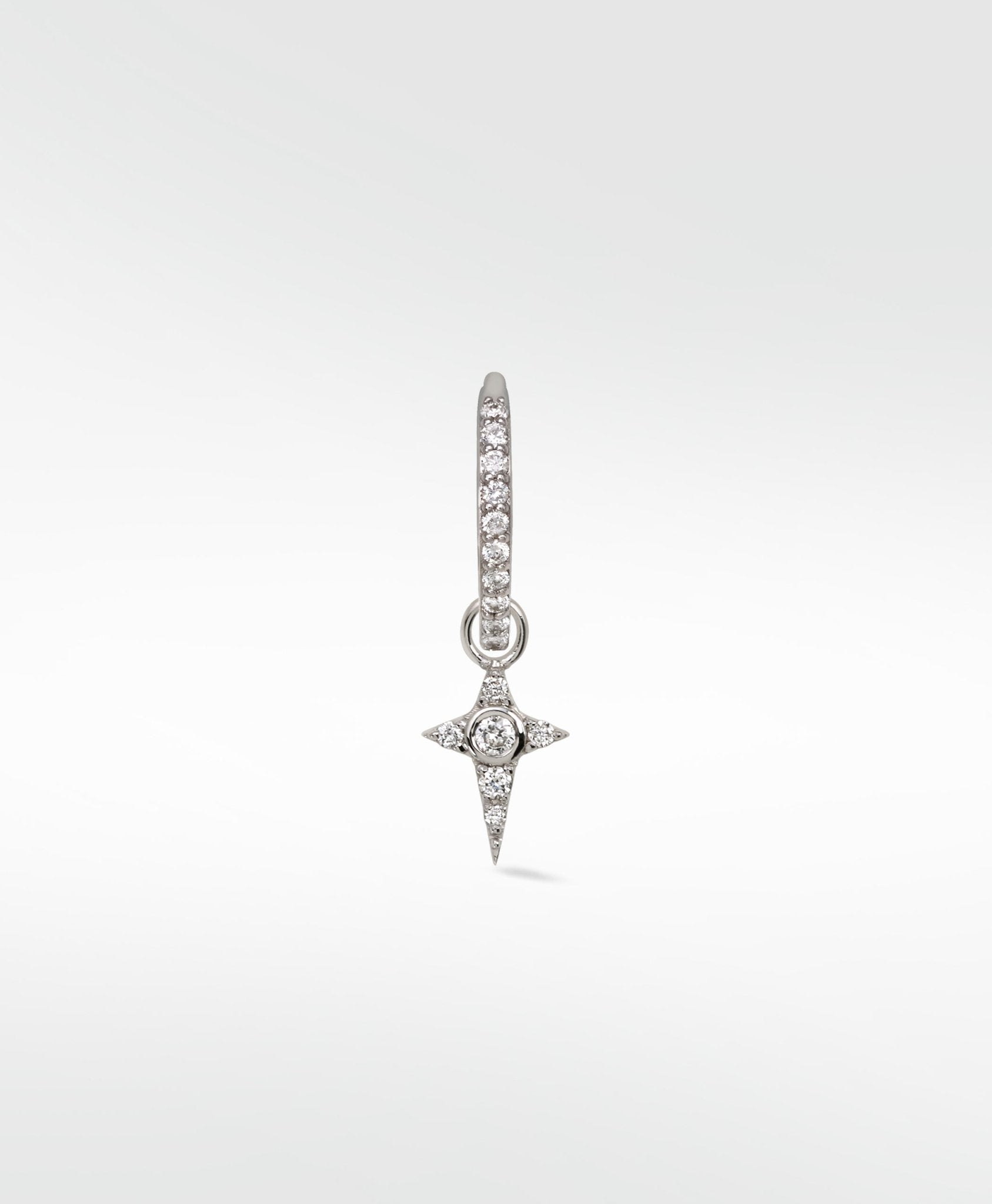A Celestial Diamond Charm in white gold with a pavé star design hanging from a small diamond hoop earring.