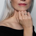 A model with silver hair showcases the Lark & Berry Eclipsis Mother of Pearl and Diamond Ring, her hand resting on her chin.