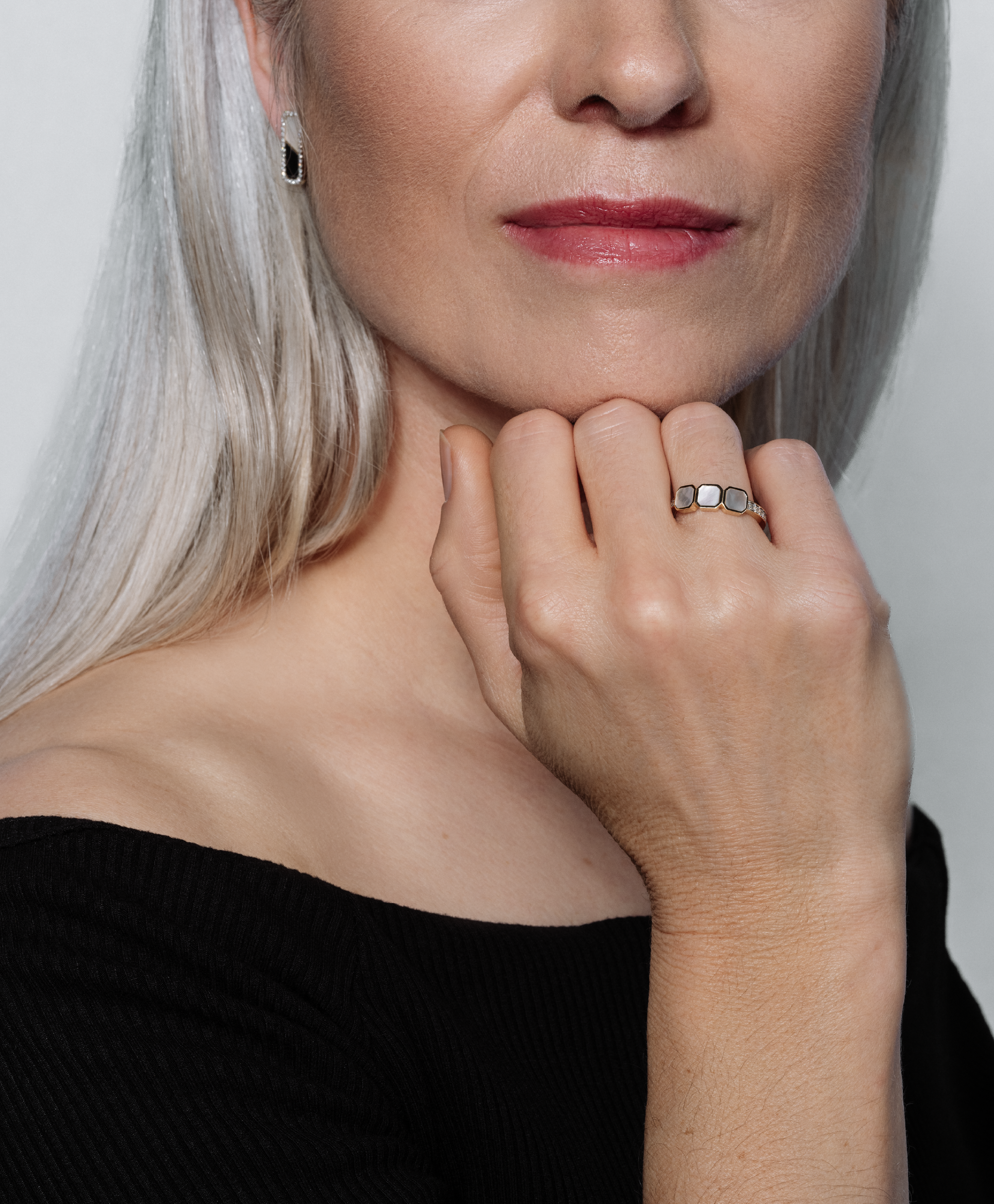 A model with silver hair showcases the Lark & Berry Eclipsis Mother of Pearl and Diamond Ring, her hand resting on her chin.